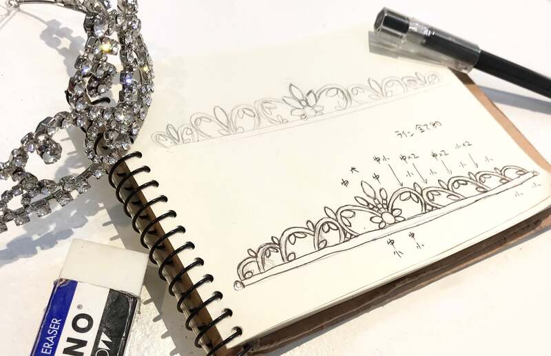 ブライダルアクセサリー マリコのオーダーメイドティアラのデザイン画と完成品。スケッチブックにクリスタルの配置や大きさを細かく書き込んだ設計図と、実際に完成したティアラが並んでいる。